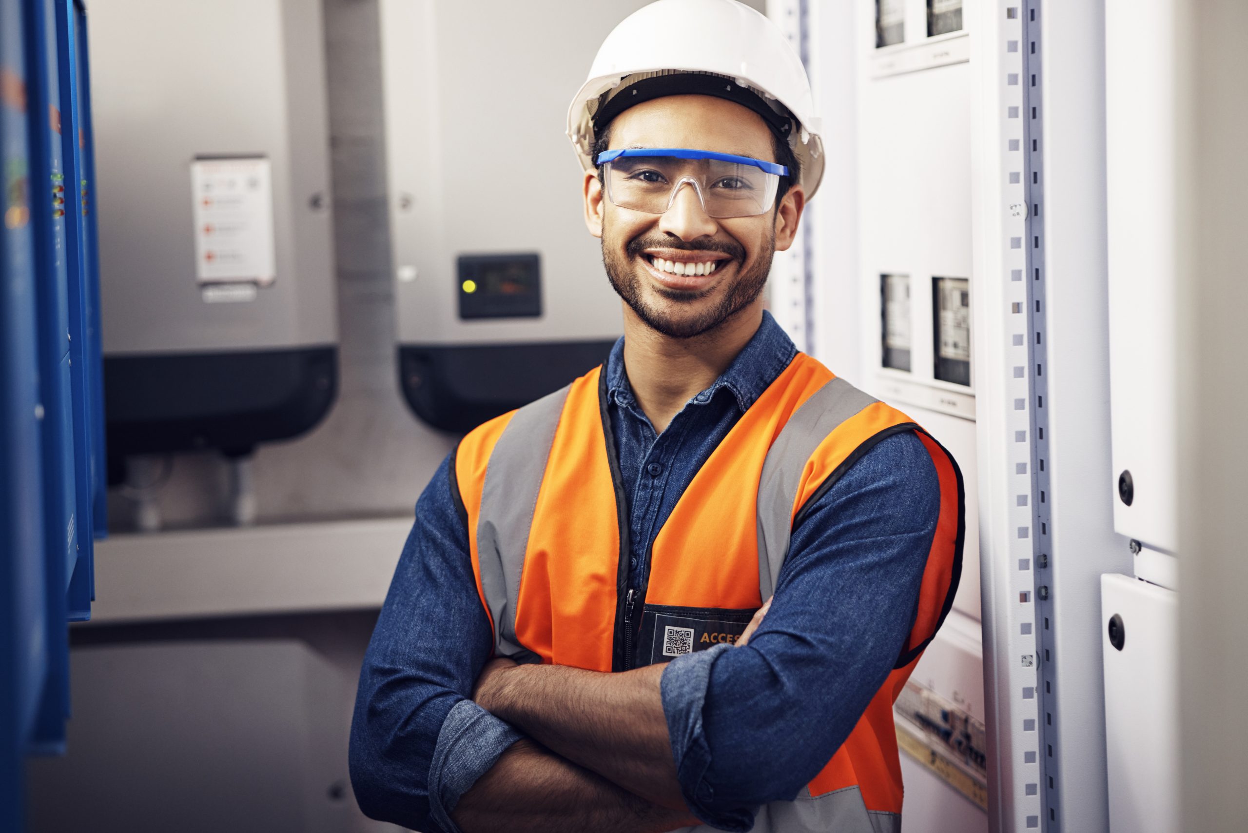 Portrait, happy man and engineering technician in control room, inspection service or industry maintenance. Electrician, arms crossed and smile in electrical substation, system or industrial mechanic.